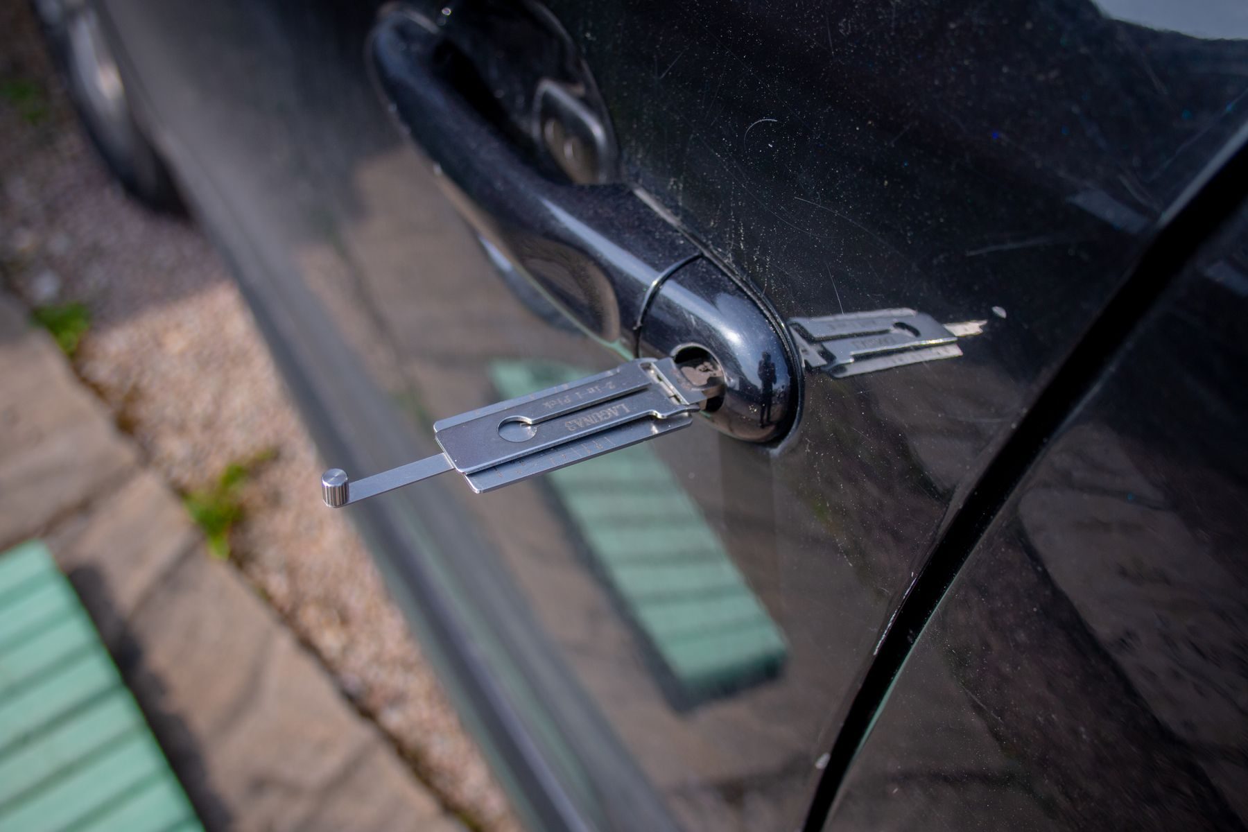Locksmith tool inserted into a car door handle