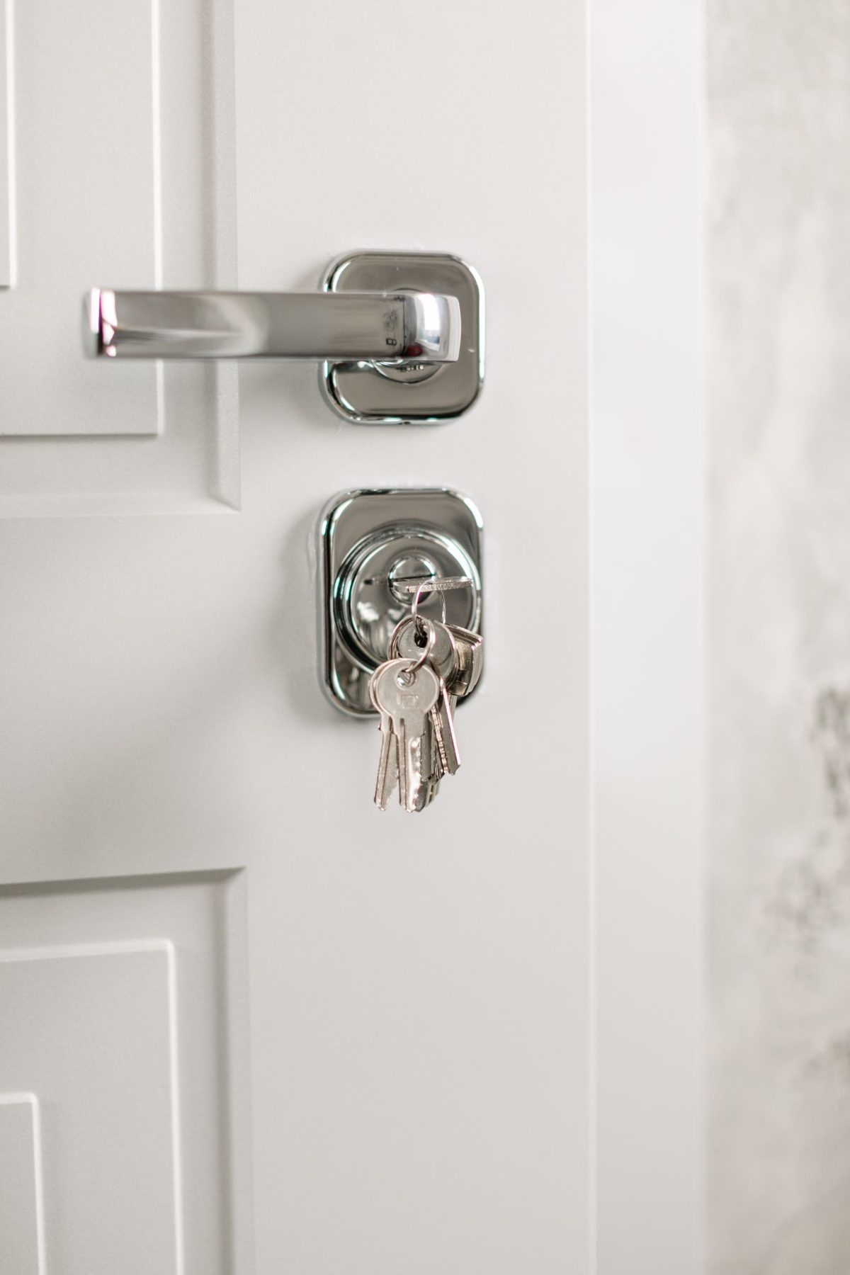 Deadbolt and lever handle on a white interior door with keys in the lock