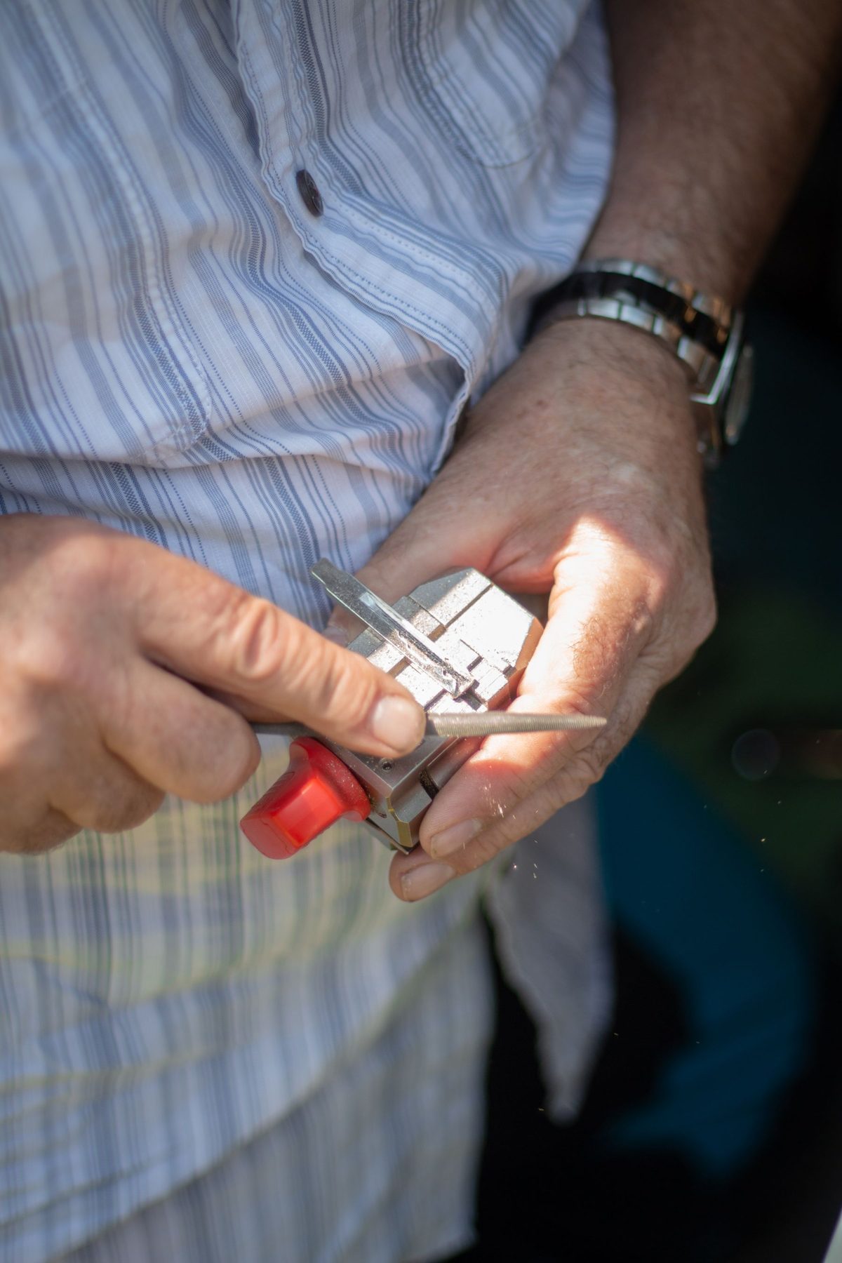 Close-up of hands filing a key blade